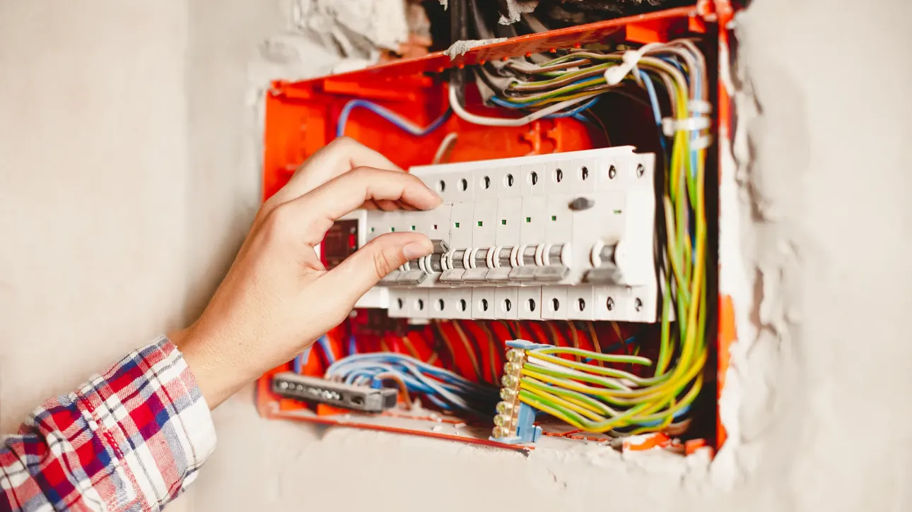 Electrician installing GFCI outlet to resolve electrical code violation found in home inspection